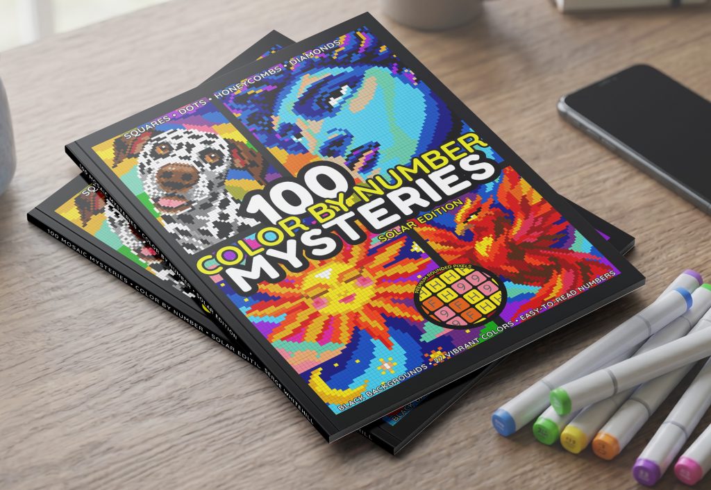 100 Mysteries Solar Edition color by number book – paperback on desk with markers